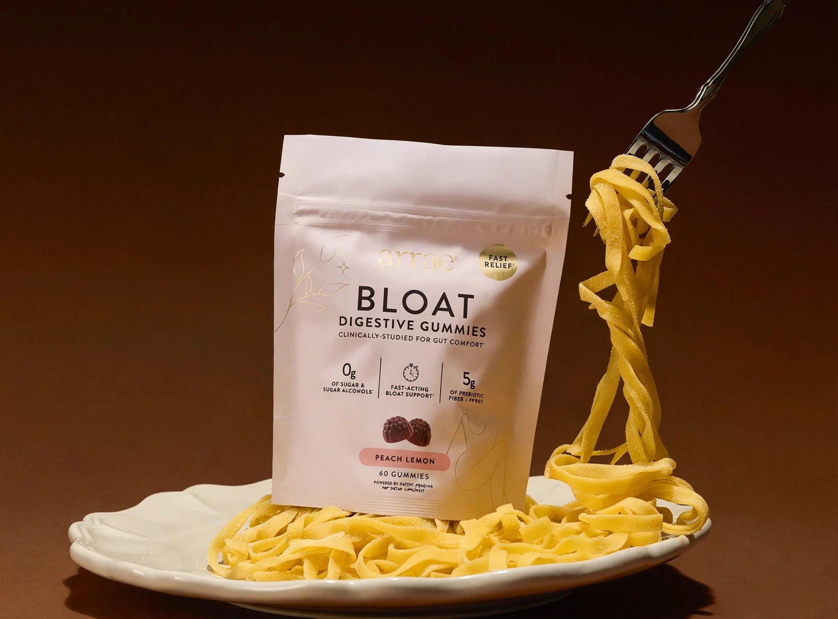 Arrae Bloat gummies pouch with a plate of pasta.