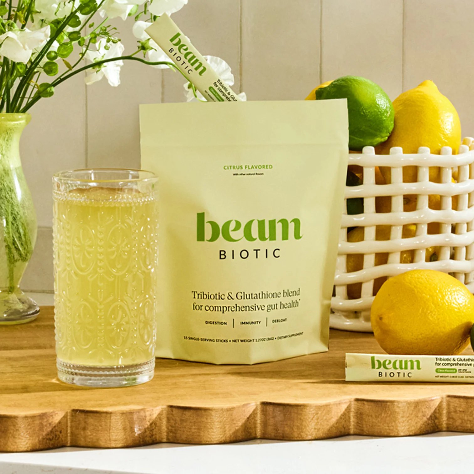 Beam Biotic pouch with a glass of citrus drink and lemons.