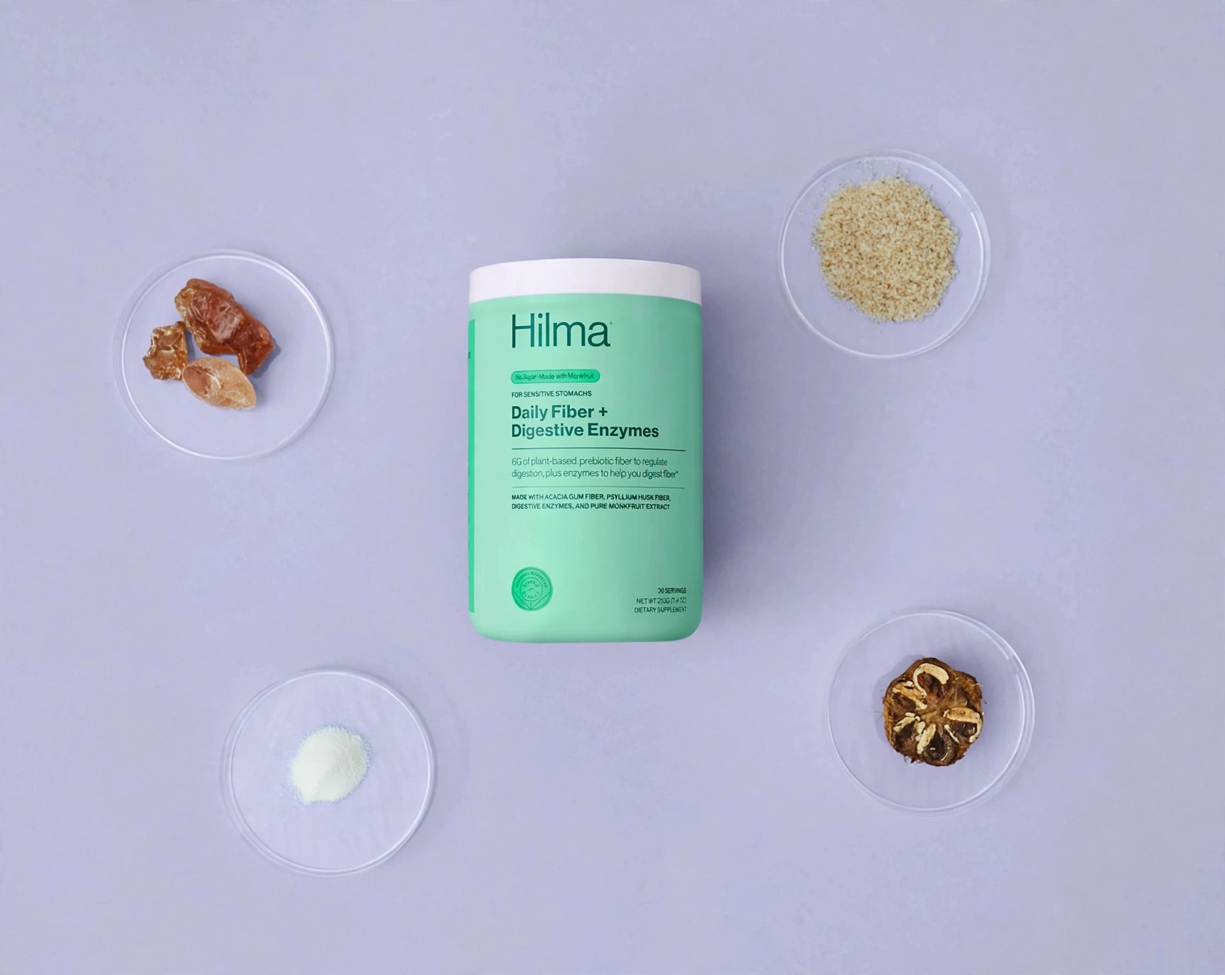 Hilma Daily Fiber canister with ingredient dishes on lilac background.