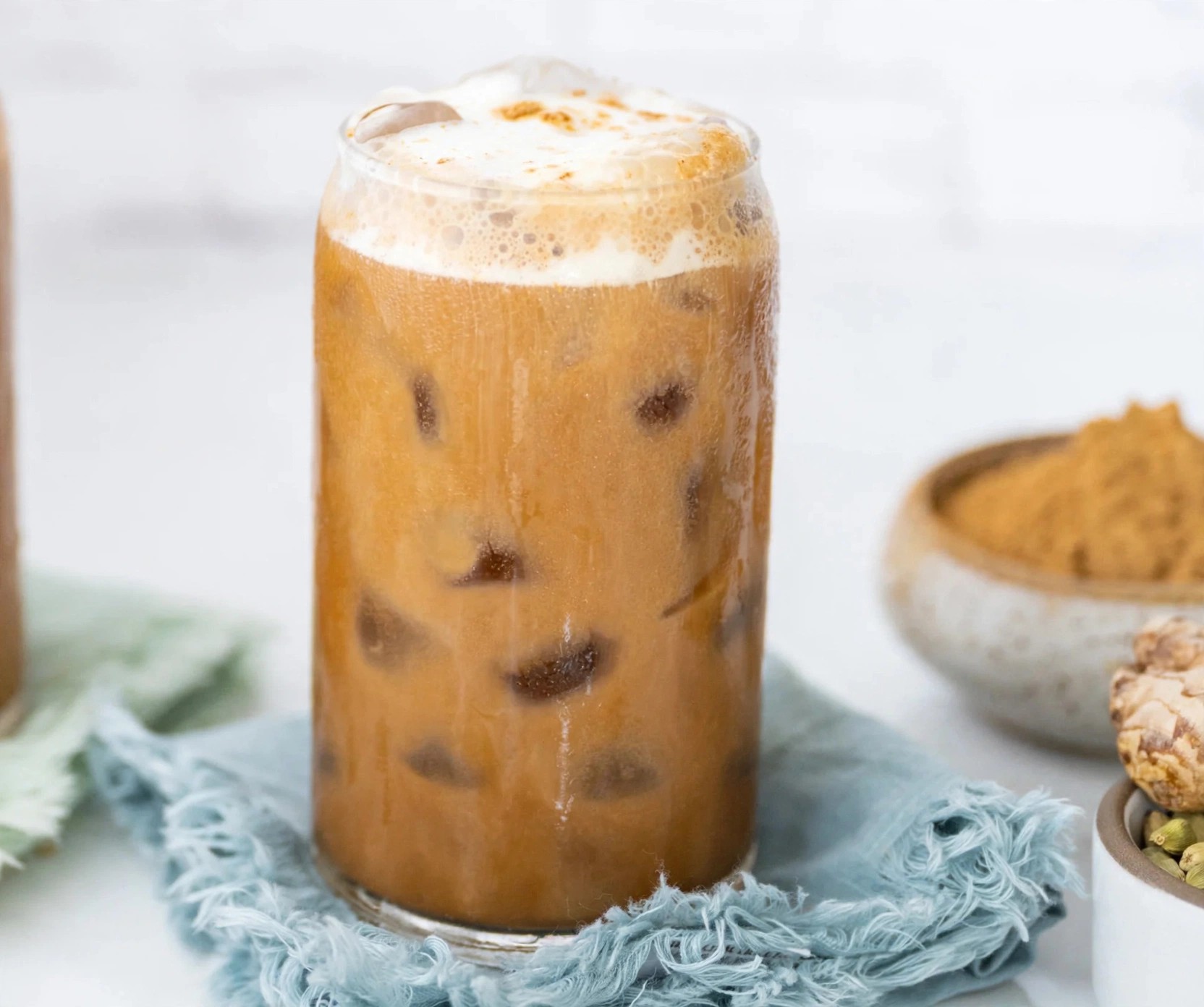 Iced MUDWTR latte in a glass beside powdered ingredients.