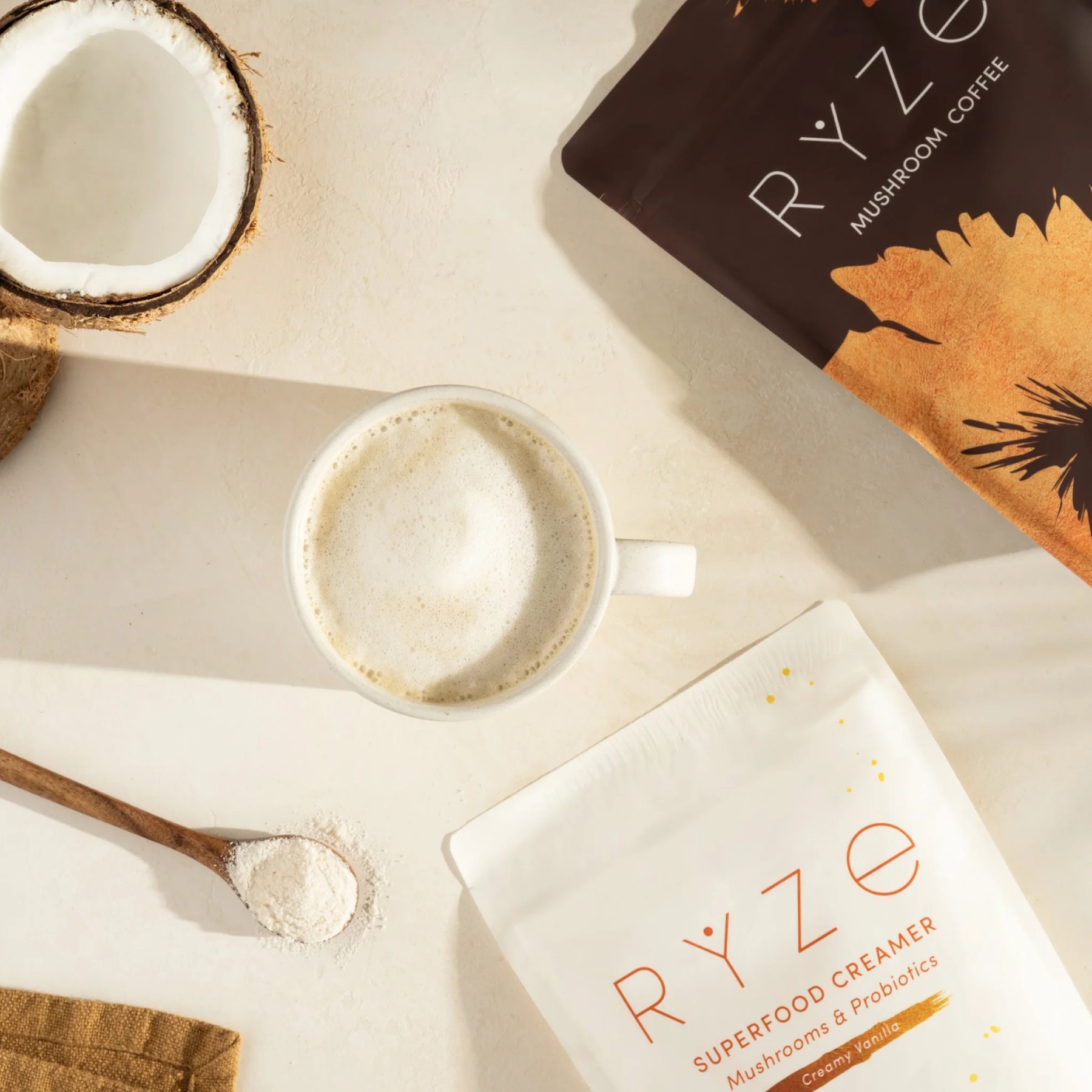 A cup of mushroom coffee with creamer powder and pouches.